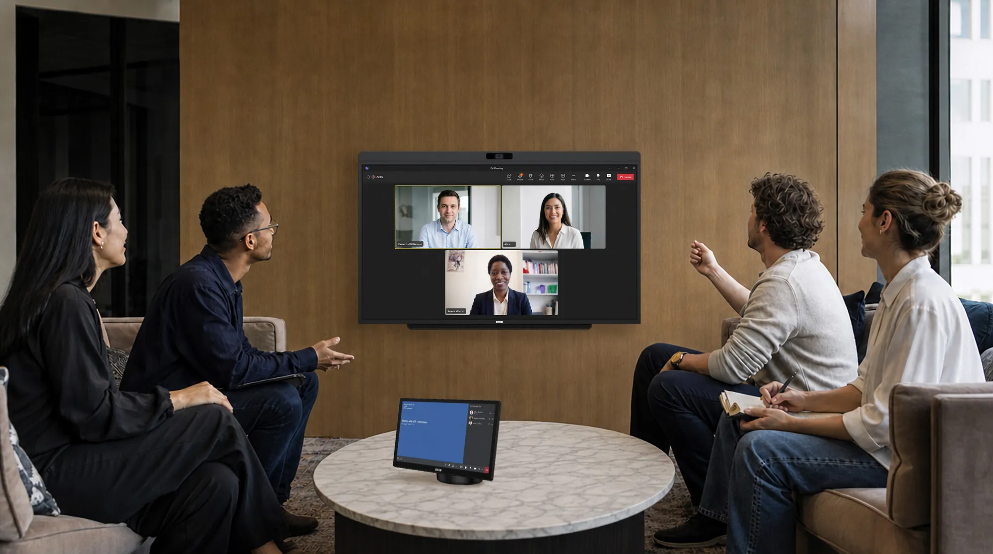 Team in a lounge meeting space with DTEN system on the wall